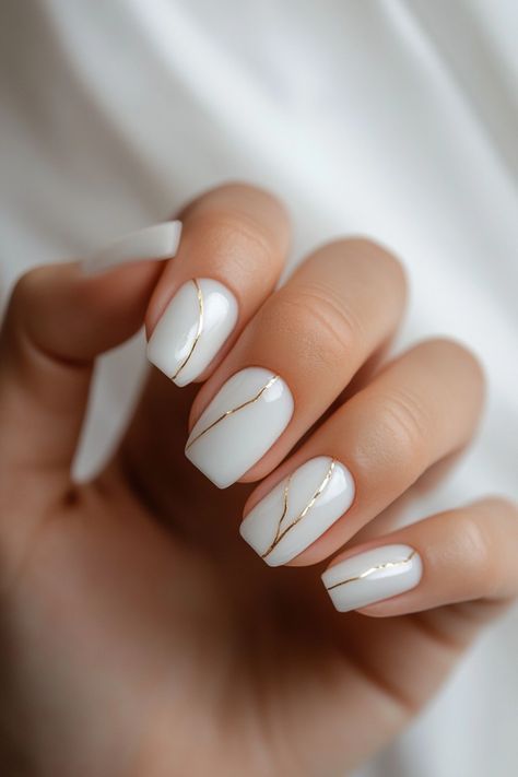 Short French tip nails with modern white line designs on nude base, showcasing stylish and trendy nail art for 2025.